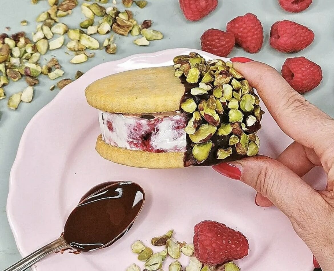 Gelato variegato al lampone e biscotto alla vaniglia, ricoperto di cioccolato e pistacchi