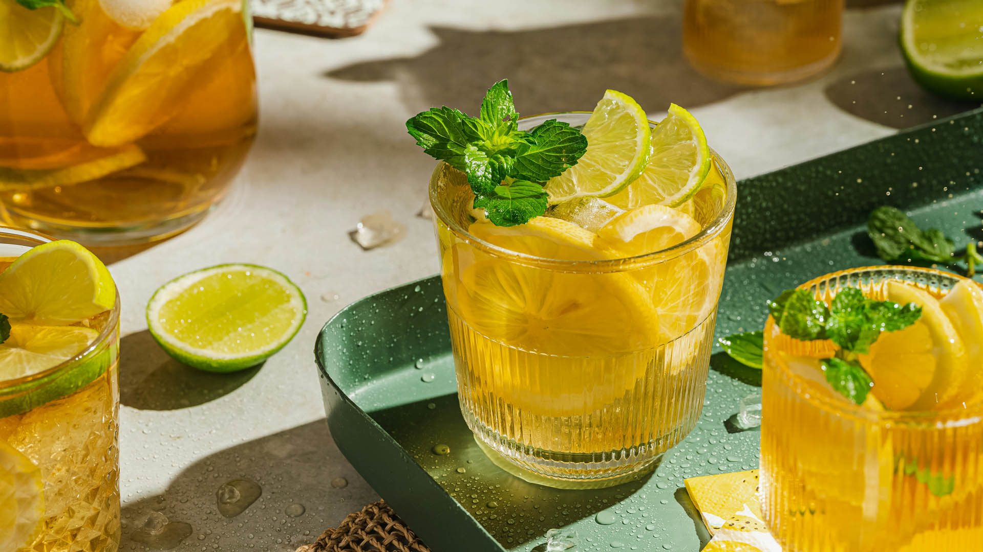 Bicchiere di cocktail analcolico alla frutta guarnito con fette di limone e menta fresca.
