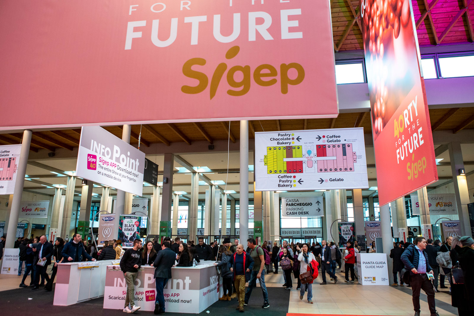 Vista panoramica della Fiera SIGEP 2025 a Rimini, con espositori e visitatori impegnati in attività dimostrative nei settori gelateria, pasticceria, panificazione e caffè.