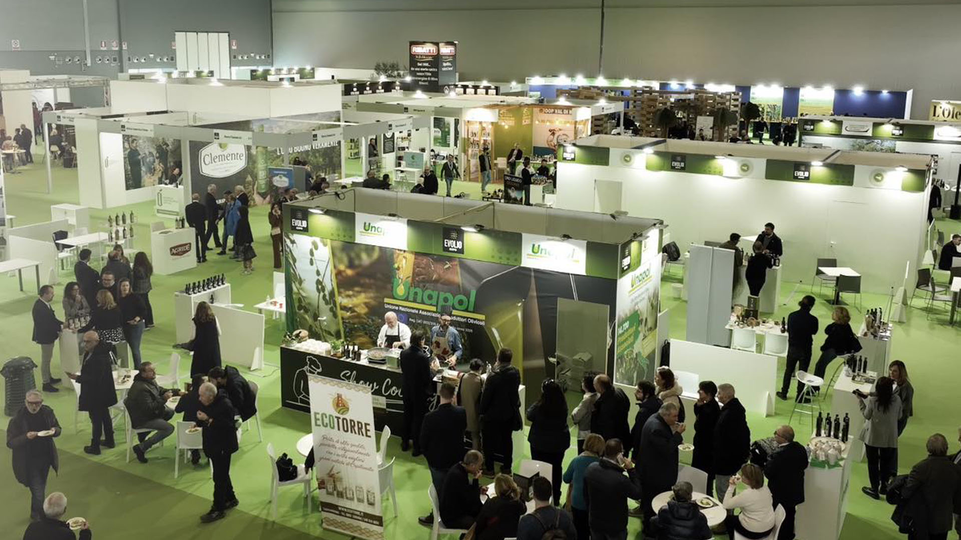 Vista panoramica di Levante PROF 2025, la fiera internazionale dedicata all'eno-agroalimentare. Stand espositivi, aziende del settore e visitatori interagiscono tra degustazioni, incontri di business e presentazioni di prodotti enogastronomici. Atmosfera dinamica e professionale all'interno del padiglione della Fiera del Levante di Bari.