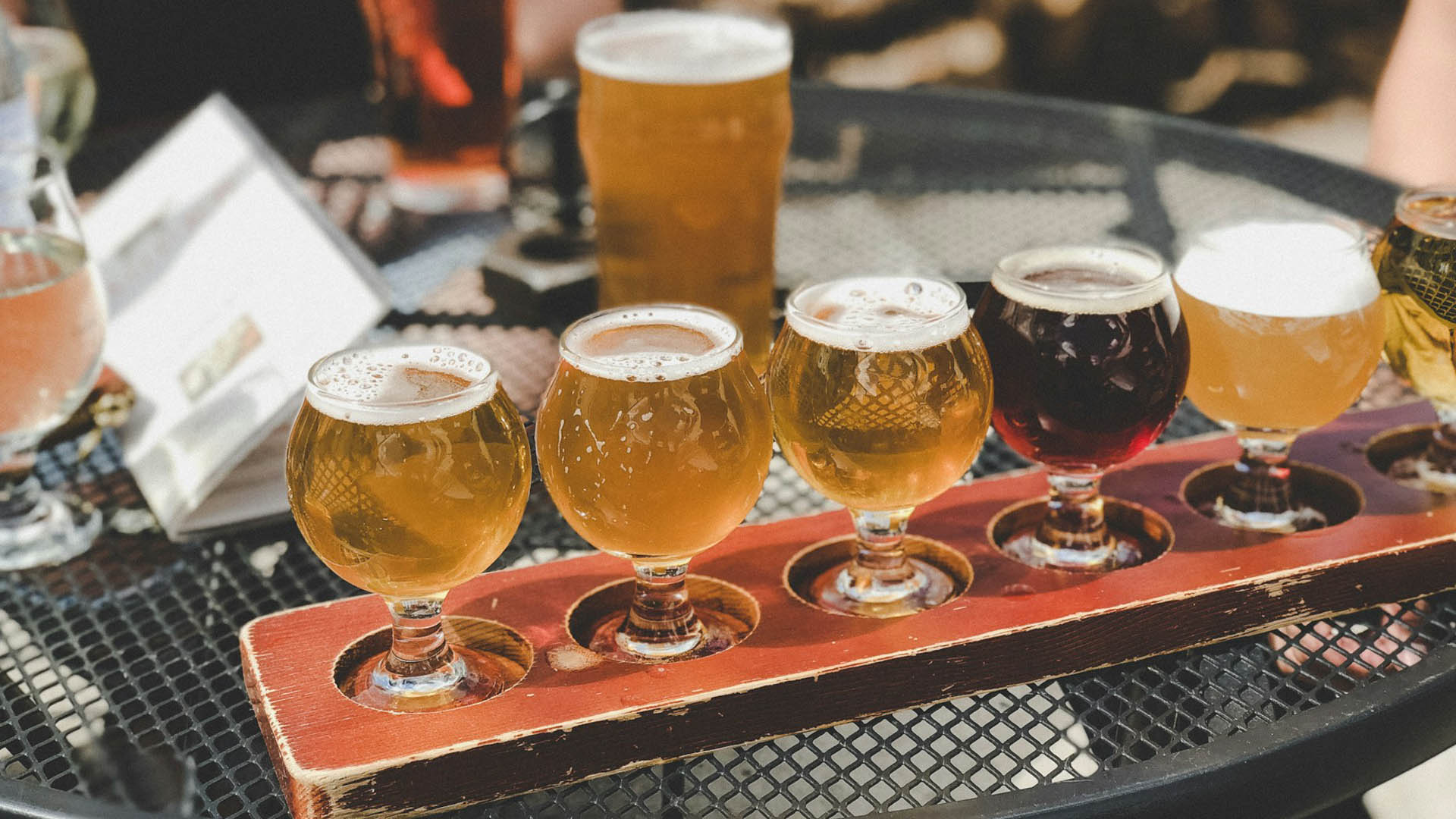 Degustazione di birre artigianali servite in piccoli bicchieri su vassoio in legno durante il Panza Marche Beer Fest al Castello della Rancia di Tolentino.