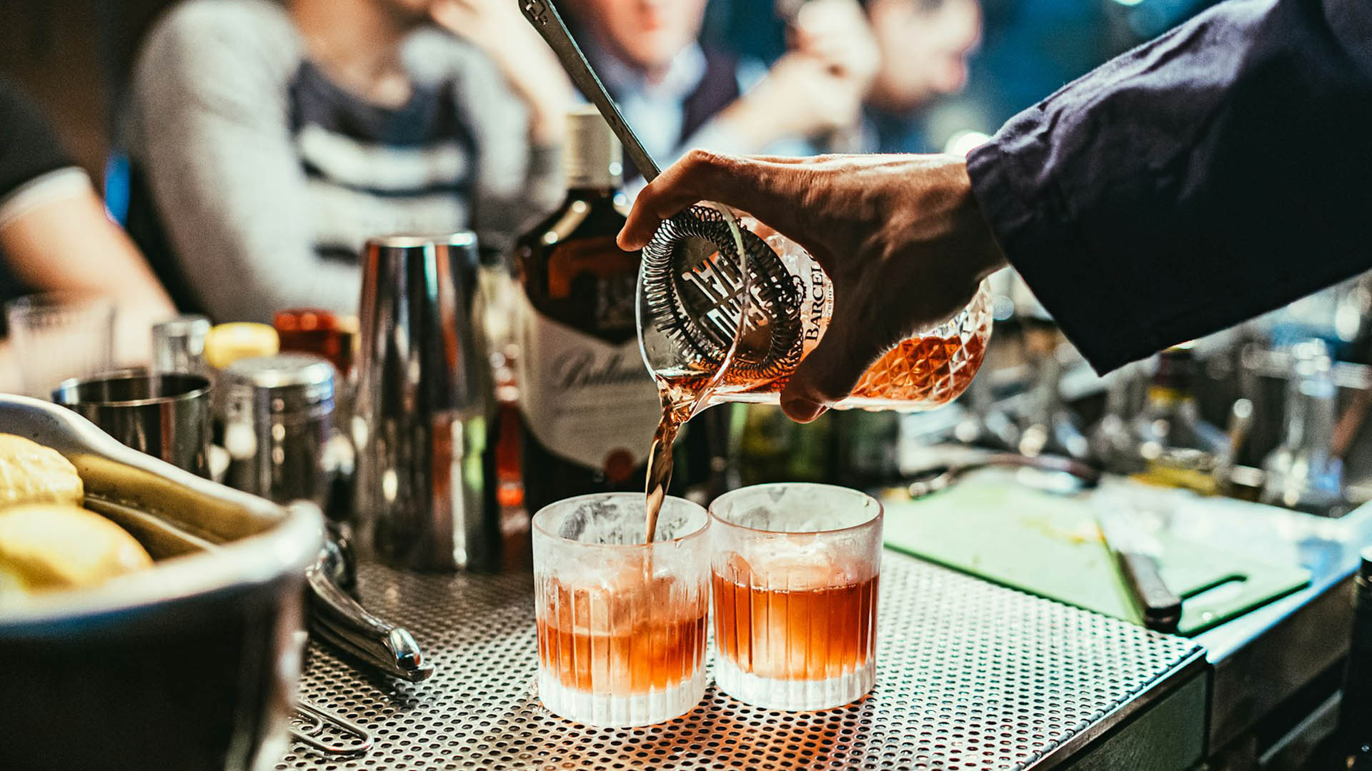 Bartender che versa due cocktail durante il World Aperitivo Day, evento dedicato alla cultura dell’aperitivo italiano celebrato il 26 maggio in tutto il mondo.