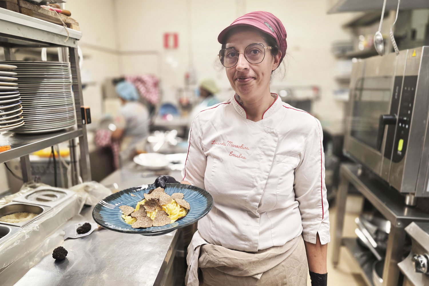 Dove mangiare bene a Parma – la cuoca Emilia della Locanda Marzolara prepara un piatto al tartufo di Fragno nella cucina emiliana tradizionale