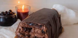 Lingottino cioccolato e amarene: l’eleganza del dolce al cucchiaio in chiave moderna Lingottino cioccolato e amarene con crema al fondente e glassa croccante su tagliere di legno