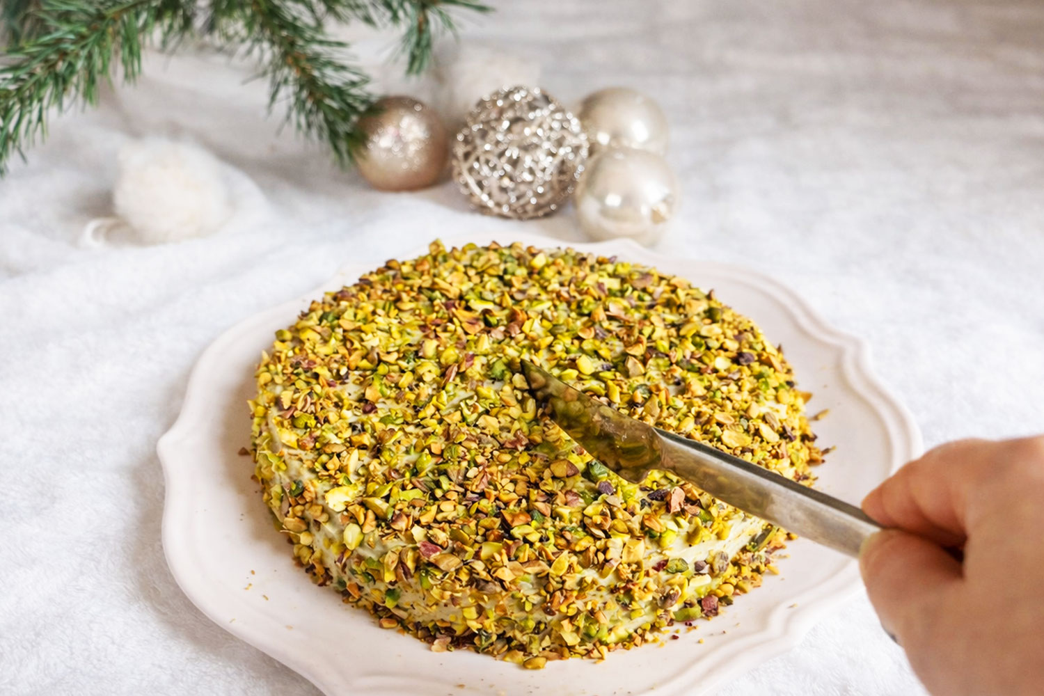 Dolce al pistacchio cremosissimo senza forno ricoperto di granella, con coltello pronto al taglio, dessert al cucchiaio ideale per le feste