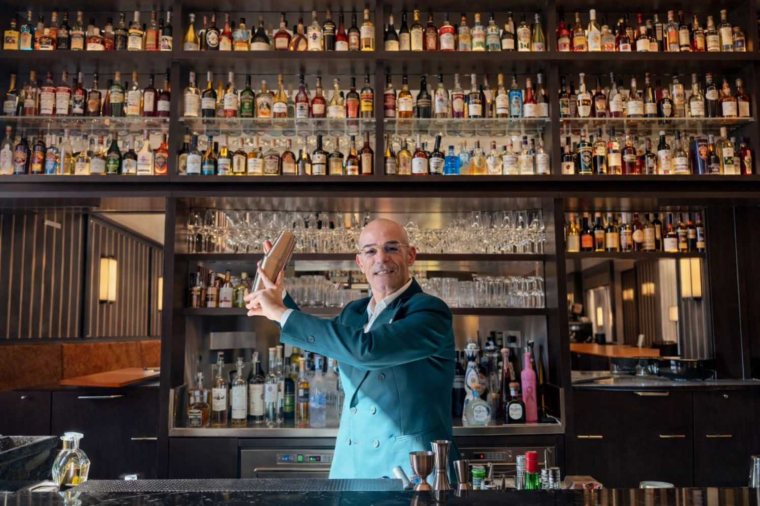 Valentino Gallitelli bartender al Chiostro Bar di Vista Ostuni durante la preparazione di un cocktail, simbolo della mixology negli hotel di lusso