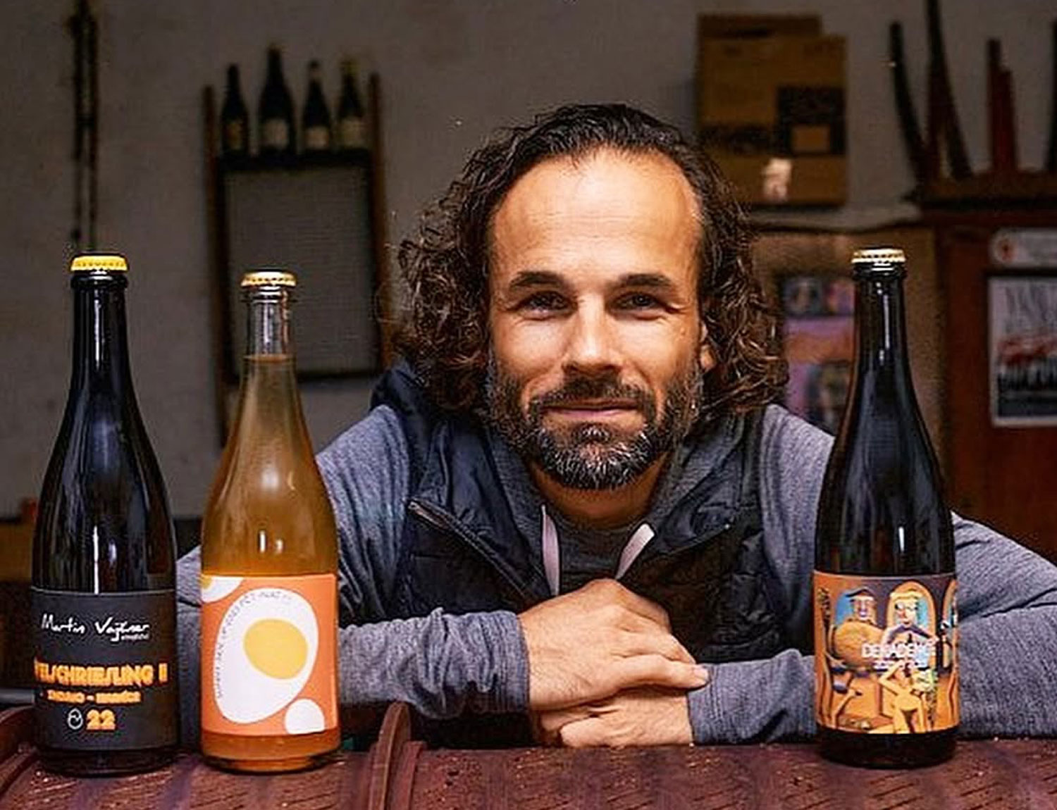 Vini naturali cechi Martin Vajcner ritratto del vignaiolo con bottiglie della sua produzione naturale in Moravia meridionale