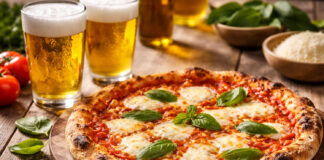 Birra e pizza margherita: gli abbinamenti perfetti Birra e pizza margherita servite insieme con bicchieri di lager come esempio di abbinamento tra pizza e birra in pizzeria