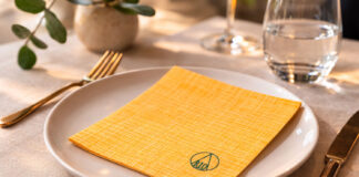 La nuova tavola della ristorazione tra eleganza e sostenibilità tovagliolo sostenibile giallo su tavola elegante ristorante mise en place moderna