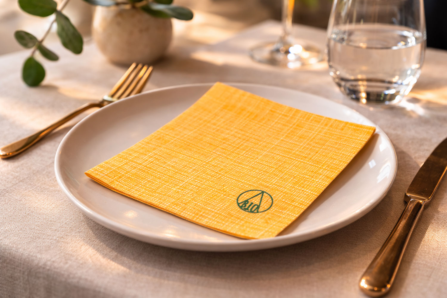 tovagliolo sostenibile giallo su tavola elegante ristorante mise en place moderna