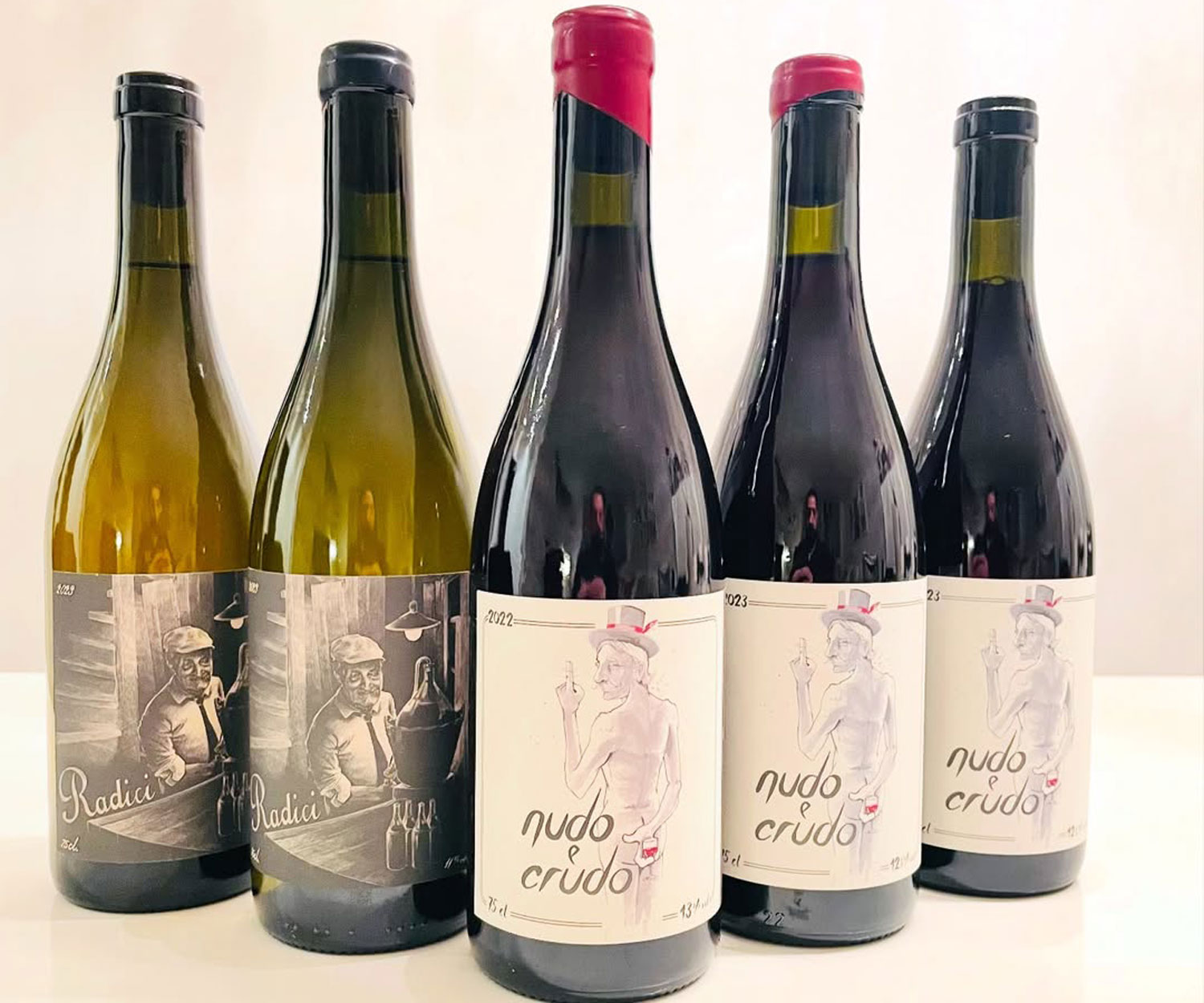 Vini naturali Svizzera Wir Komplizer con etichette Radici e Nudo Crudo su bottiglie artigianali