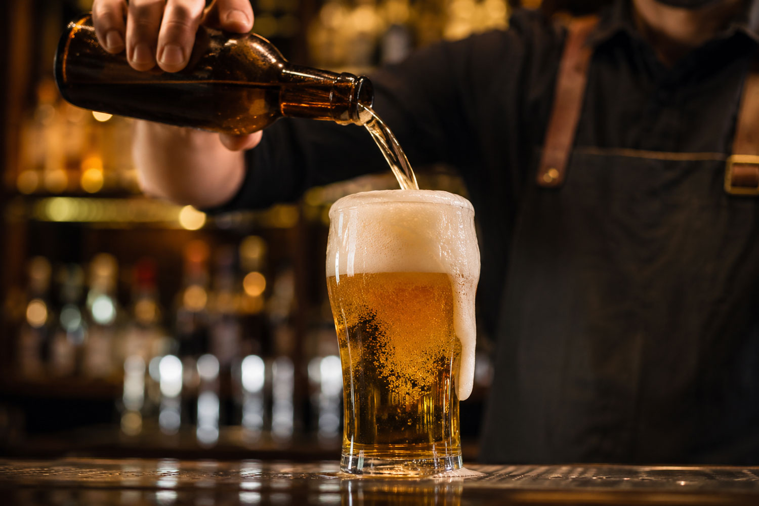 Birra servita male con schiuma eccessiva durante la mescita al bancone di un pub