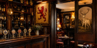 Pub inglesi: cosa sono le snug e altre curiosità Pub inglesi con handpump, snug tradizionale, insegne storiche e Sunday roast servito al tavolo.