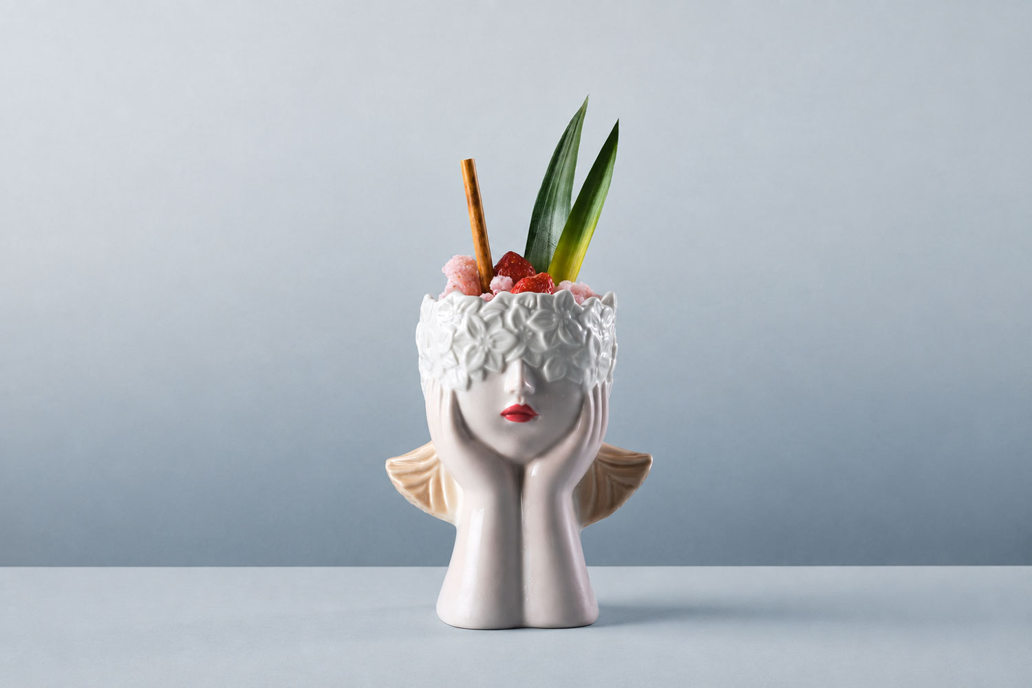 Cocktail gastronomico con fragole e garnish vegetale servito in un bicchiere scultoreo, esempio della mixology raccontata in Cucina Liquida