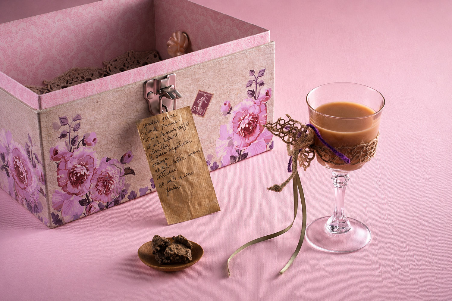 Cocktail con scatola decorata e nota scritta a mano, esempio di storytelling sensoriale nella mixology di Cucina Liquida.