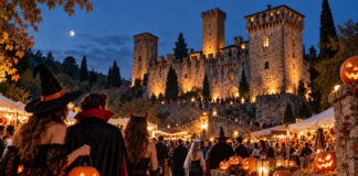 Halloween 2026 in Italia: 82 feste ed eventi Halloween 2026, festa con persone in costume, zucche illuminate e castello medievale sullo sfondo.